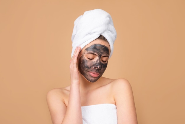 Beautiful girl with mud on his face cosmetic mask beauty face\
mud facial mask face clay mask spa bea
