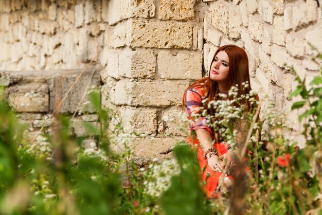 Beautiful girl with orange hair in plaid shirt and red pink skirt