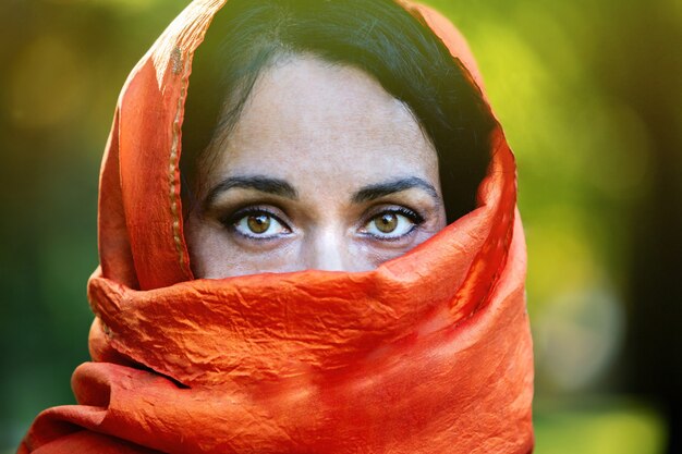 Beautiful girl with a orange scarf in a park