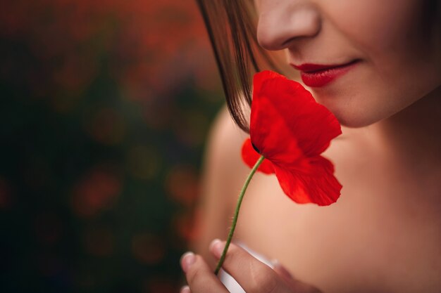 Beautiful girl with poppy seeds near face close up