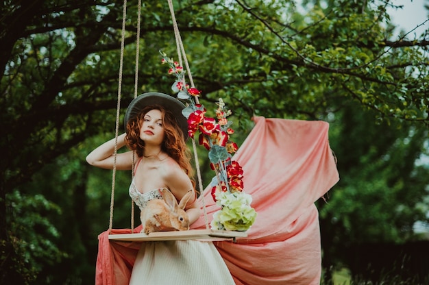 beautiful girl with a rabbit outdoors in summer day