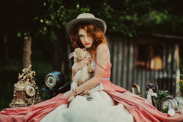 beautiful girl with a rabbit outdoors in summer day