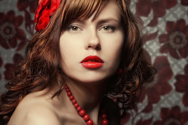 Beautiful girl with red flower in hair