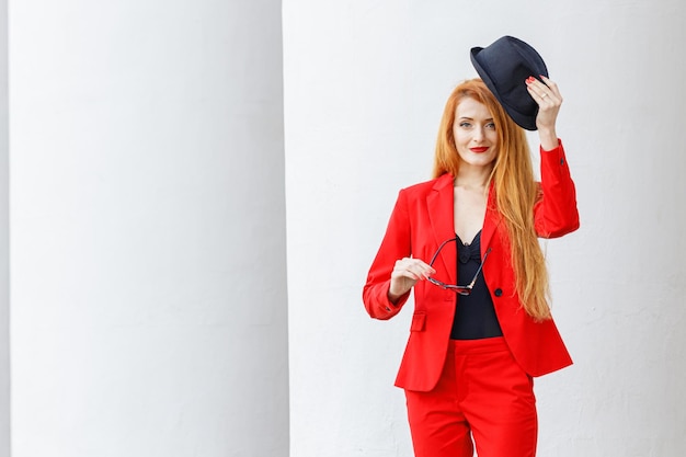 Foto bella ragazza con i capelli rossi vestita con un tailleur rosso ritratto di affari