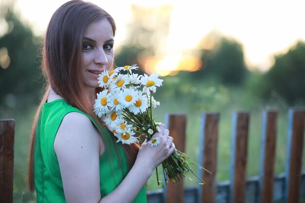 Beautiful girl with red hair with a bouquet