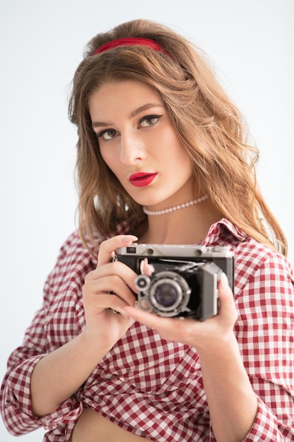 Красивая девушка с ретро-камерой Женщина-фотограф в стиле пятидесятых