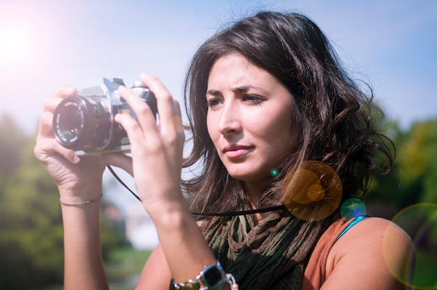 beautiful girl with scarf and camera on the lawn