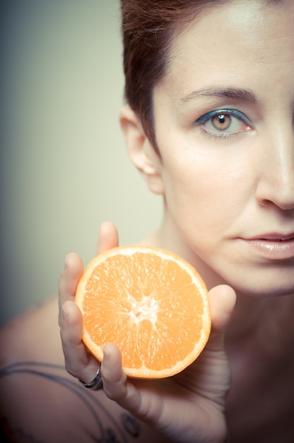 Foto bella ragazza con capelli rossi corti e frutta