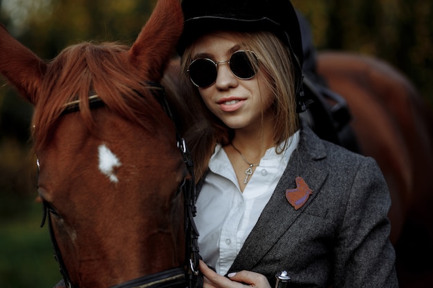 Beautiful girl with sunglasses near horse outdoors