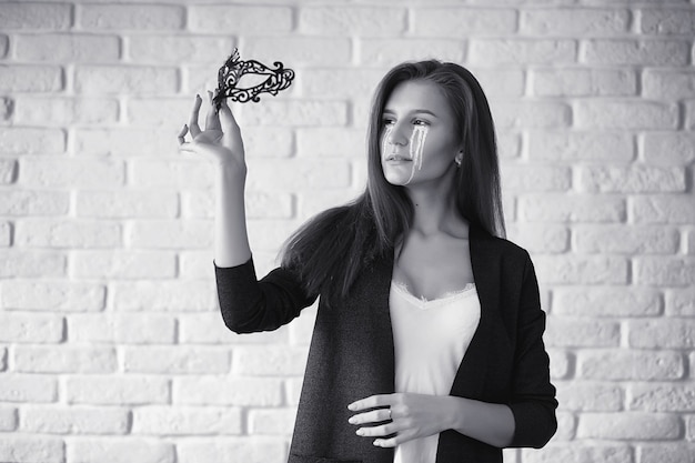 Bella ragazza con le lacrime agli occhi. ragazza giovane con lacrime dipinte in posa sulla macchina fotografica. ragazza per carnevale con maschera e trucco.