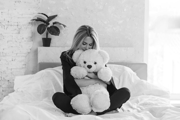 A beautiful girl with teddy bear a woman with toy the concept of childhood morning pastime