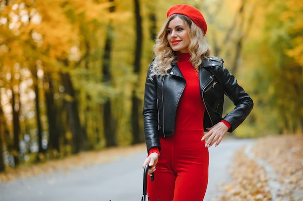 Bella ragazza con l'ombrello al parco d'autunno.