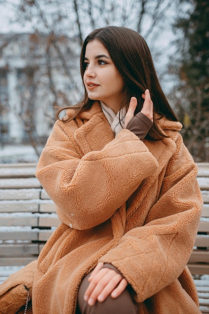 Beautiful girl woman in fur coat positive portrait