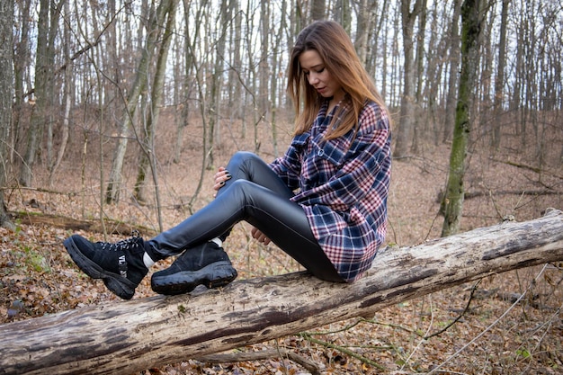 Bella ragazza nel bosco vicino agli alberi