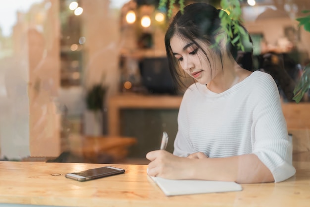 Bella ragazza che lavora sul tavolo nella caffetteria