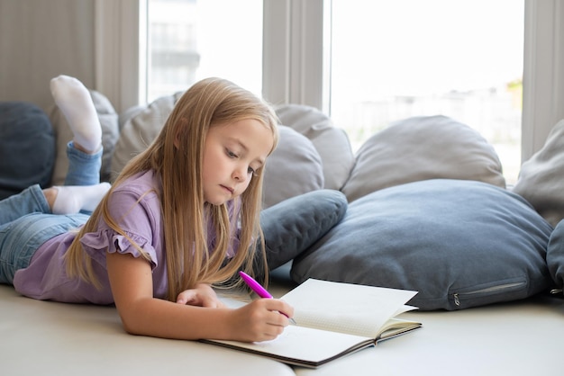 Photo a beautiful girl writes entries in her diary.smart schoolgirl doing homework, a place to copy