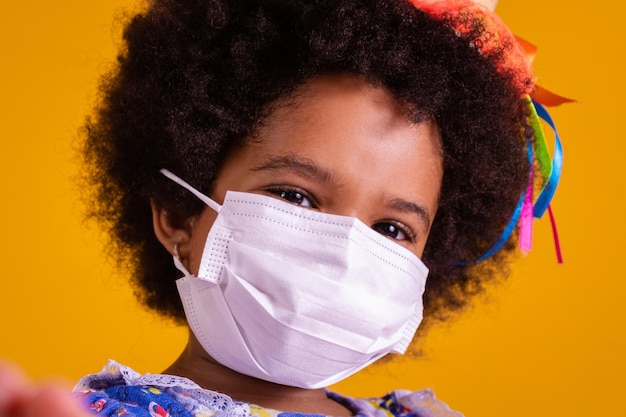 Beautiful girl on yellow background Girl in juno costume and mask for covid prevention