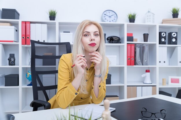 Beautiful girl in yellow dress working at her workplace