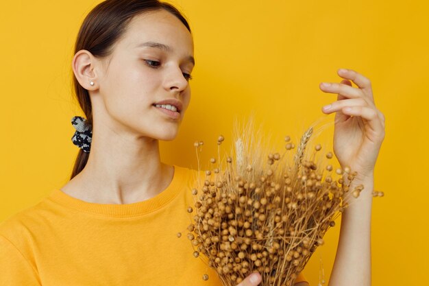 Beautiful girl in a yellow tshirt flax bouquet emotions summer style Lifestyle unaltered