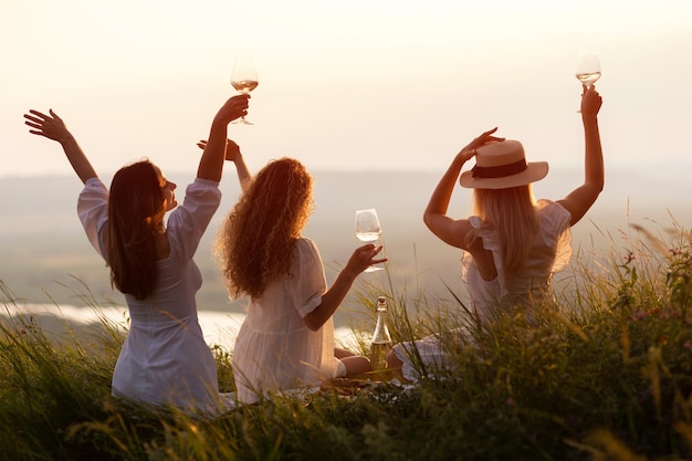 사진 여름 해가 지는 언덕에서 피크닉을 하는 아름다운 여자 친구들