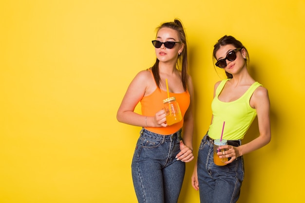 Beautiful girlfriends posing together wearing sunglasses