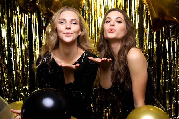 Beautiful girls celebrating New Year. Gorgeous smiling young women enjoying party celebration, having fun together.