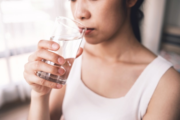 美しい女の子は、食べ物の消化を助けるなど、健康のために水を飲みます