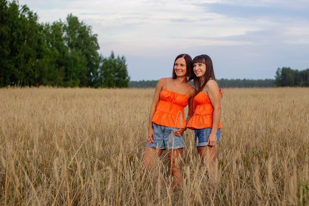 Beautiful girls in a field with wheat Milk and bread Peacetime Happiness Love Two sisters Girlfriends