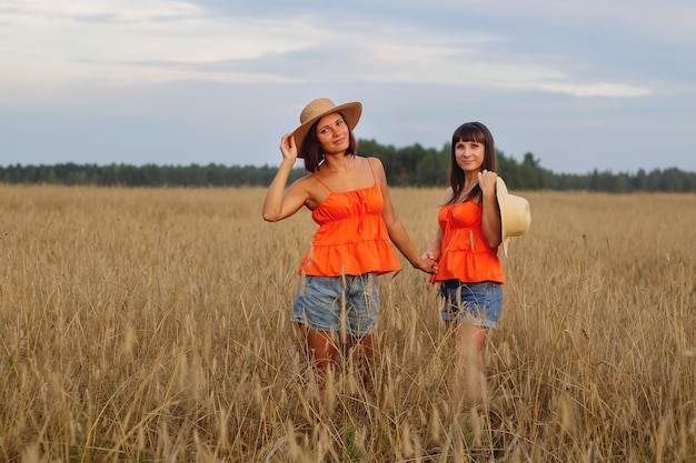 Beautiful girls in a field with wheat Milk and bread Peacetime Happiness Love Two sisters Girlfriends