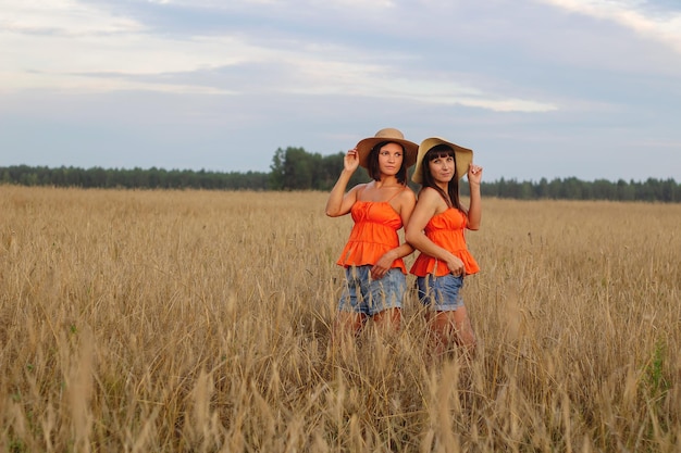 Beautiful girls in a field with wheat Milk and bread Peacetime Happiness Love Two sisters Girlfriends