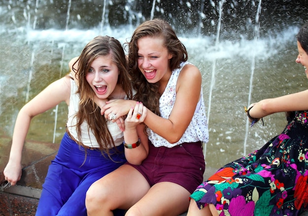 Beautiful girls having fun with a fountain.