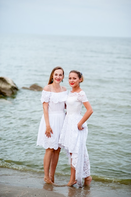 Beautiful girls in white dresses photographed on the sea