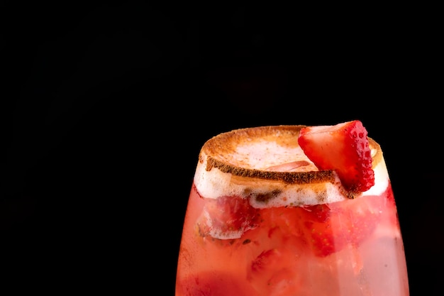 Красивый стакан клубничного коктейля с имбирной пеной с корицей на краю на деревянном столе