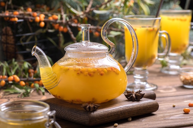 Beautiful glass teapot with sea buckthorn tea. Hot winter drinks.