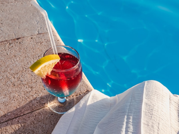 Beautiful glass with a cocktail on the pool. View from above, close-up. Concept of leisure and travel