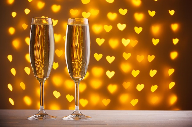 Bellissimi bicchieri di champagne su uno sfondo sfocato di cuori
