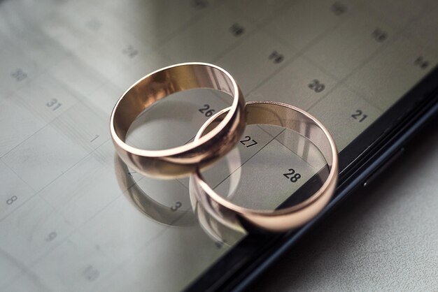 Beautiful gold wedding rings lie on the phone