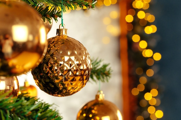 Beautiful golden bauble hanging from a christmas tree