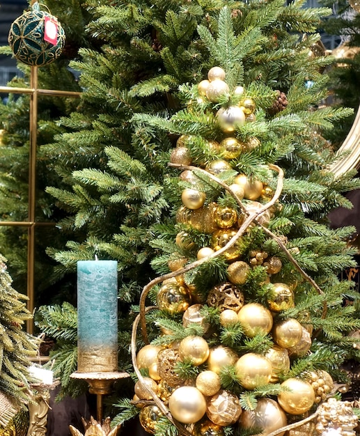 Красивые золотые новогодние шары и свечи на елке