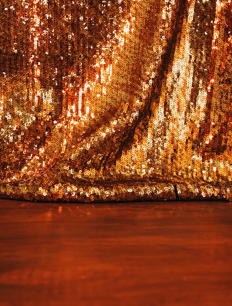 Photo beautiful golden glitter sequins background on wooden surface