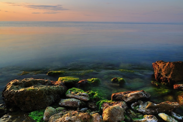クリミア半島の黒海の岩の多い海岸線に沈む夕日