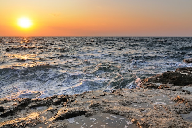 クリミア半島の黒海の岩の多い海岸線に沈む夕日