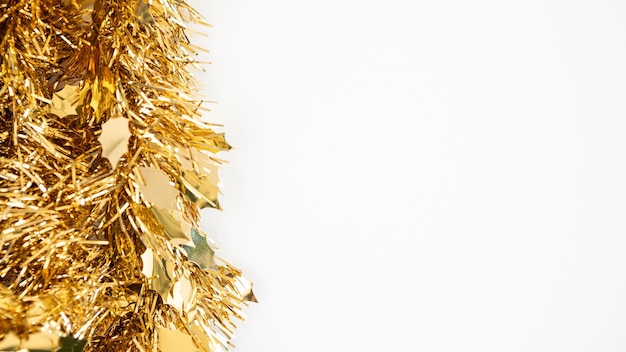 テキスト用のコピースペースを備えた冬の美しい黄金の見掛け倒しのクリスマスの伝統的な装飾。白い背景で隔離のクリスマスリボンガーランド。カード、バナー、パーティーのポスター、ヘッダーの装飾要素