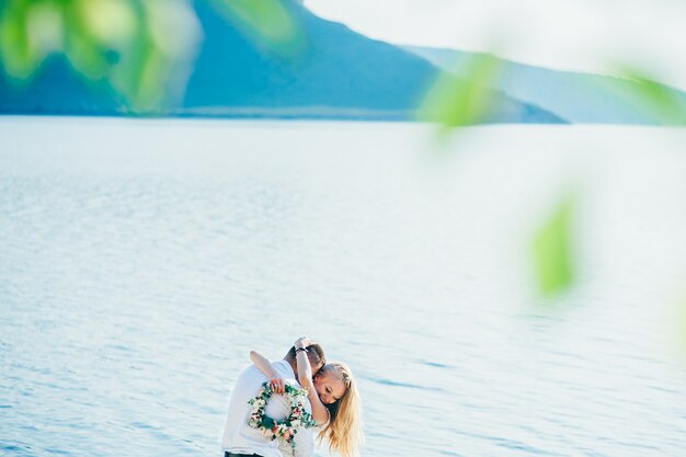 beautiful gorgeous blonde bride and stylish groom, on the background of a sea