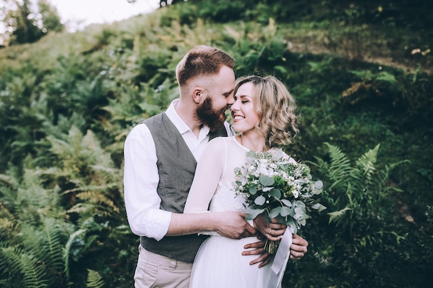 Beautiful gorgeous bride posing to groom and having fun, luxury ceremony at mountains