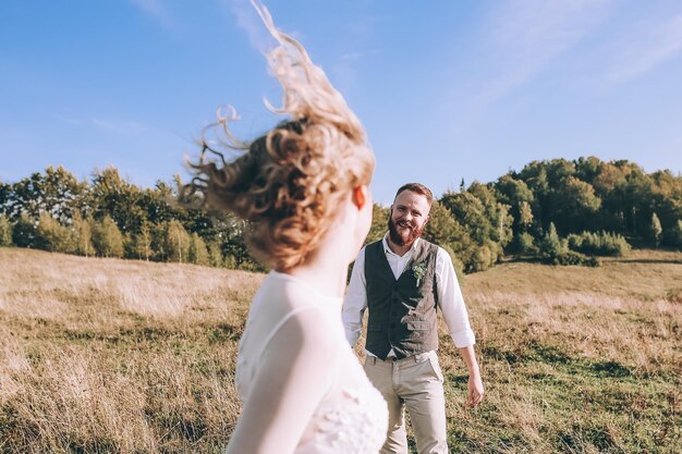 Beautiful gorgeous bride posing to groom and having fun, luxury ceremony at mountains