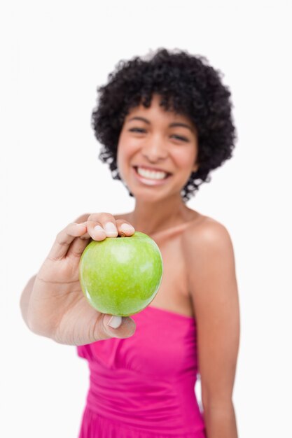 Beautiful green apple held by a young female against a white background