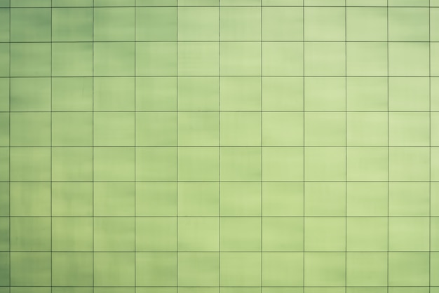 Beautiful greenish toilet, kitchen, bathroom - smooth square tiles close-up. Light green texture of wall, floor, ceiling closely with copyspace. Easy green sleek facing tile of building wall.