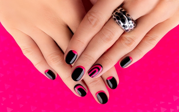 Beautiful groomed womans hands with trendy manicure on pink