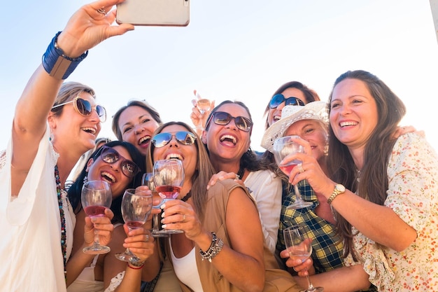 Beautiful group of people women enjoying aperitif on the terrace celebrating a birthday and a future wedding Take a selfie for absent friends with large smiles